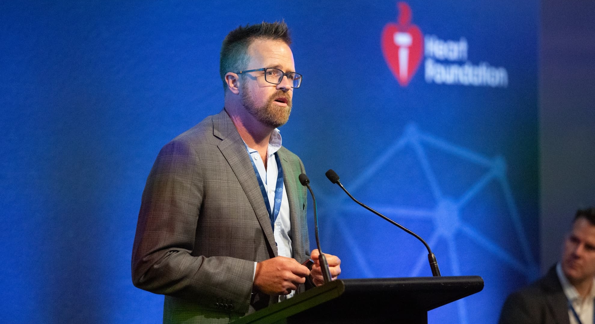 Man speaking at a lectern in front of screen that says Heart Foundation