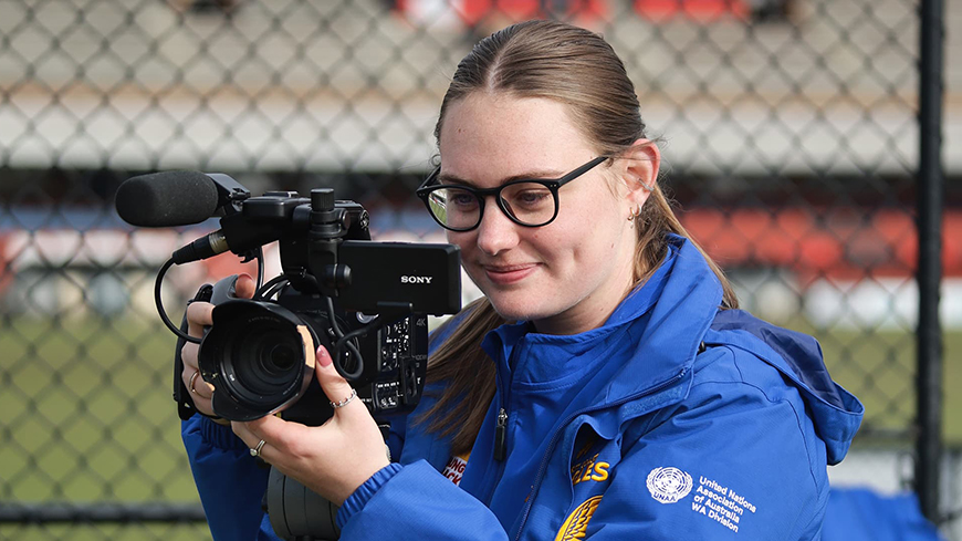 Young woman using video camera