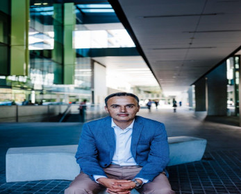Image of a man in business clothes sitting casually on a bench