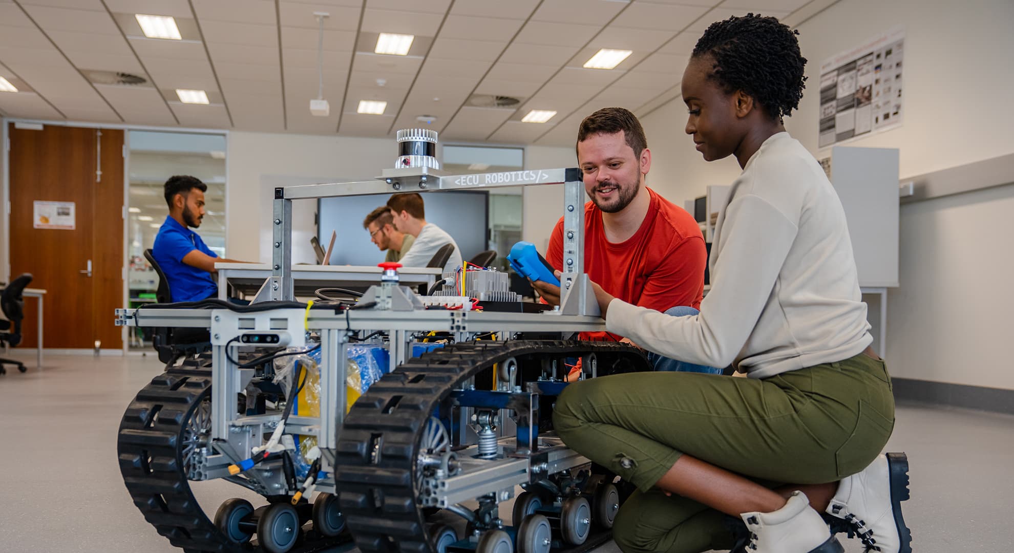 students looking at robotic car