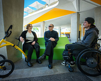 Students living with disability are socialising in the outdoor space between the Library and Student Hub at Joondalup Campus.