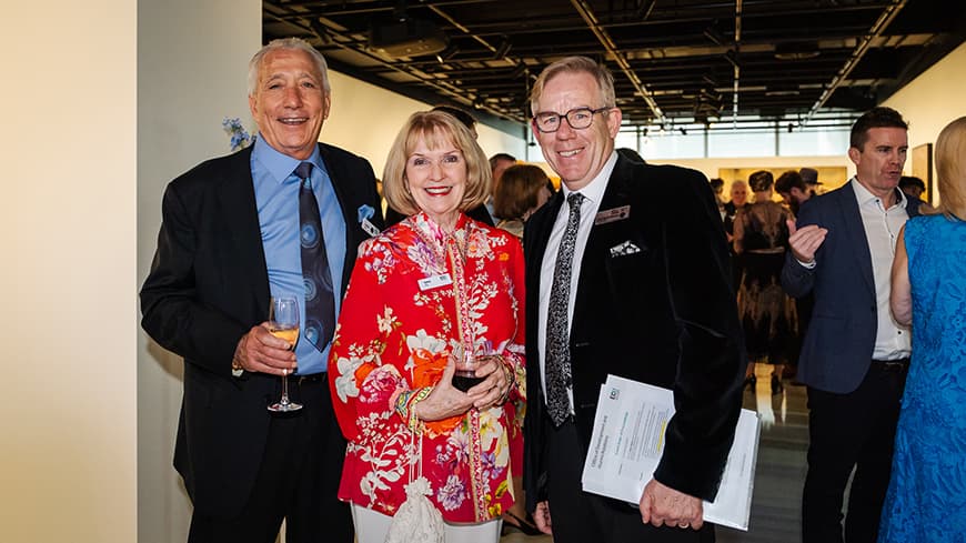 Three people standing in a group