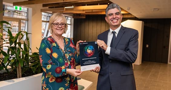 Two researchers holding and award.