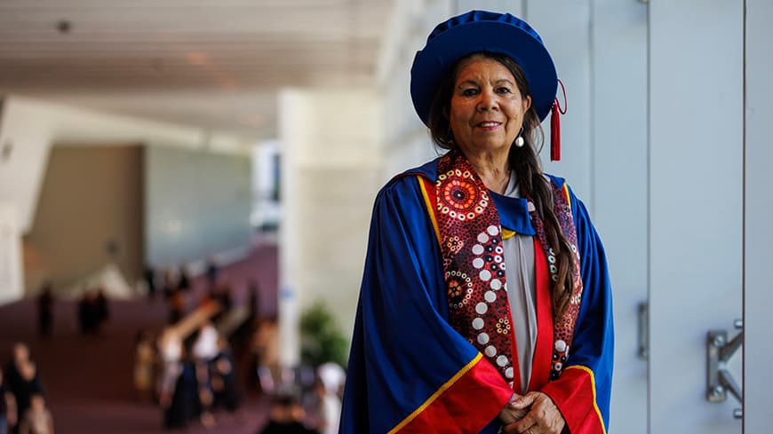Woman in full PhD graduation regalia