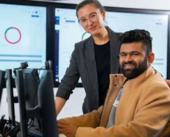Two people sitting and searching with computer
