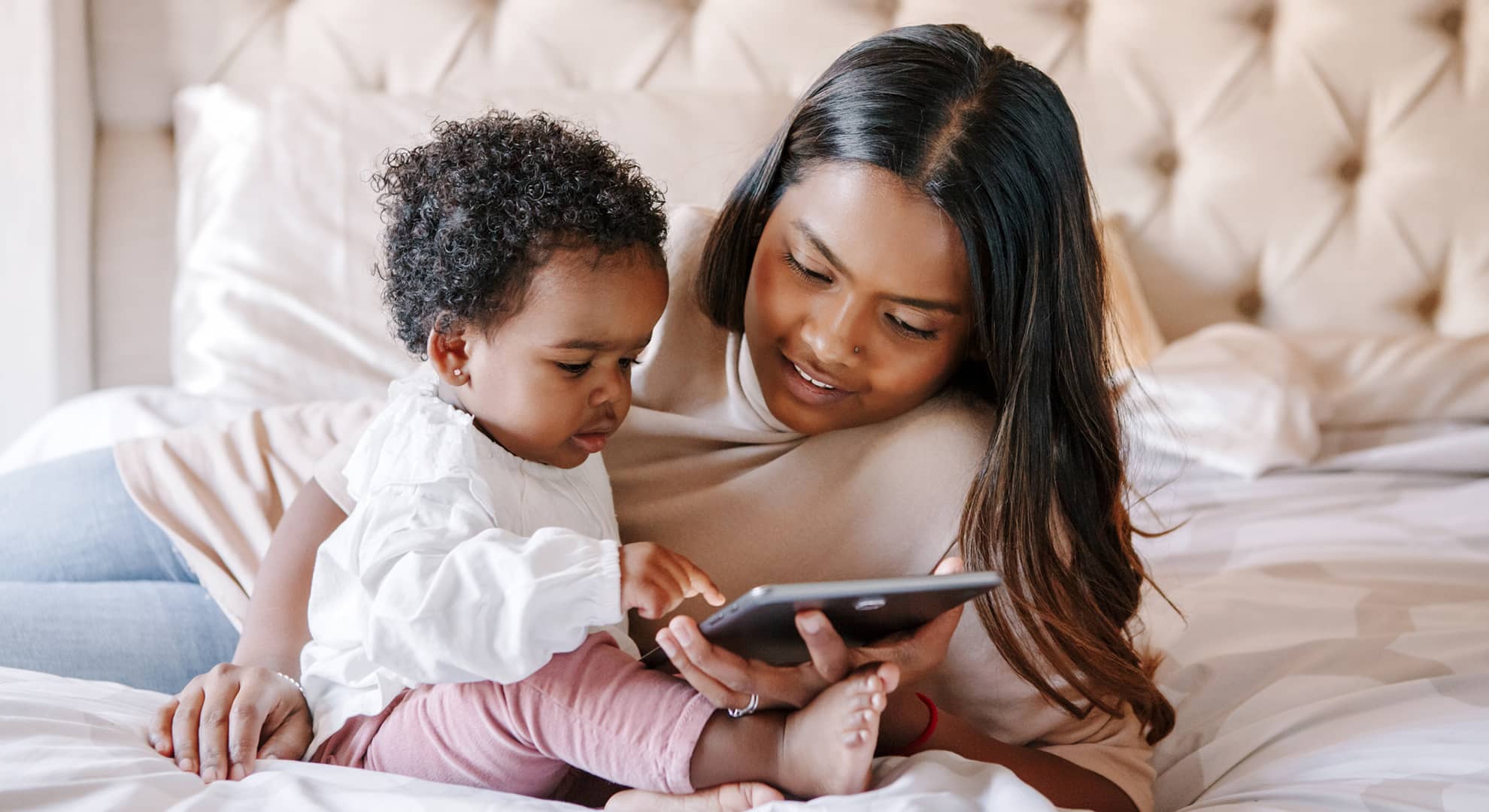 Mum with young child using ipad.