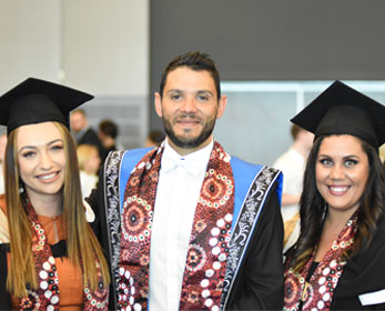 Tilly Casey, Professor Braden Hill and Tracey Lee Taraia wearing the graduation sashes.