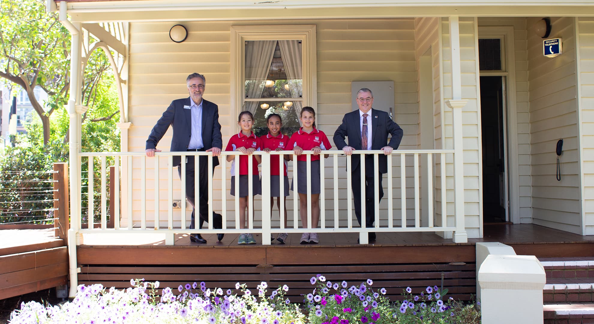 Arshad Omari, three students and Steve Chapman stand on the steps of Edith Cowan House
