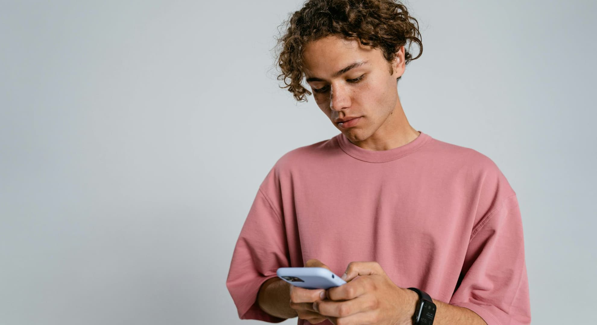 Teenage boy texting on phone.