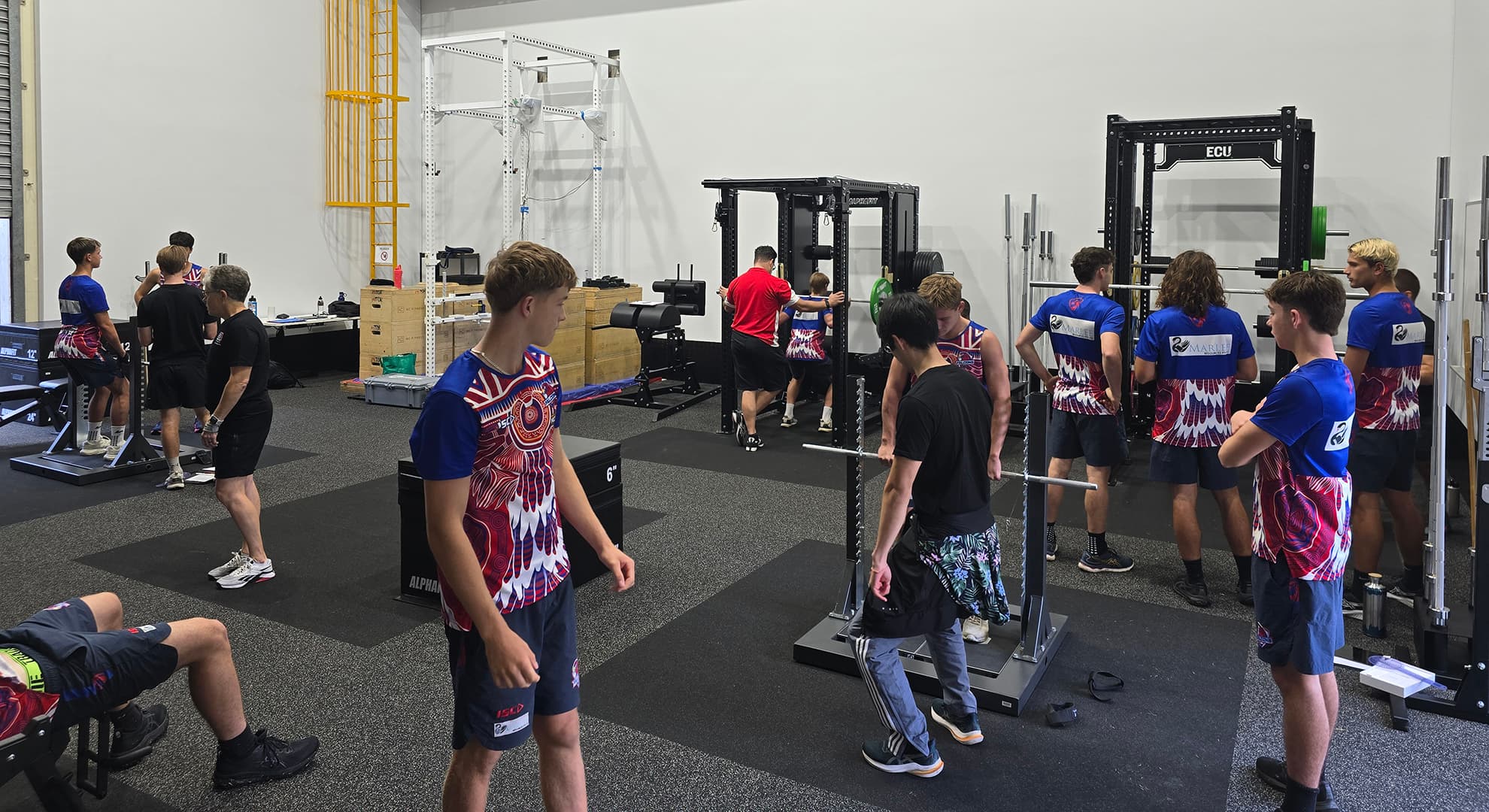A group of young football players in a strength and conditioning facility at ECU.