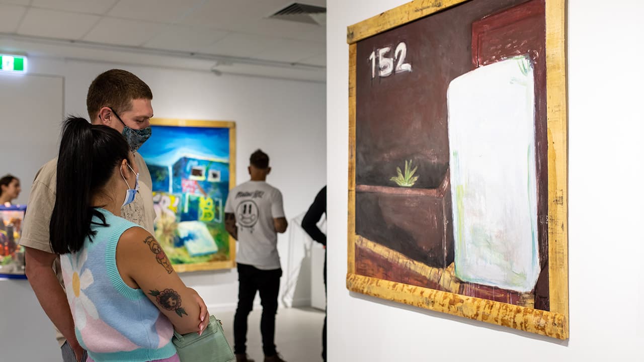 Two people viewing art in a gallery