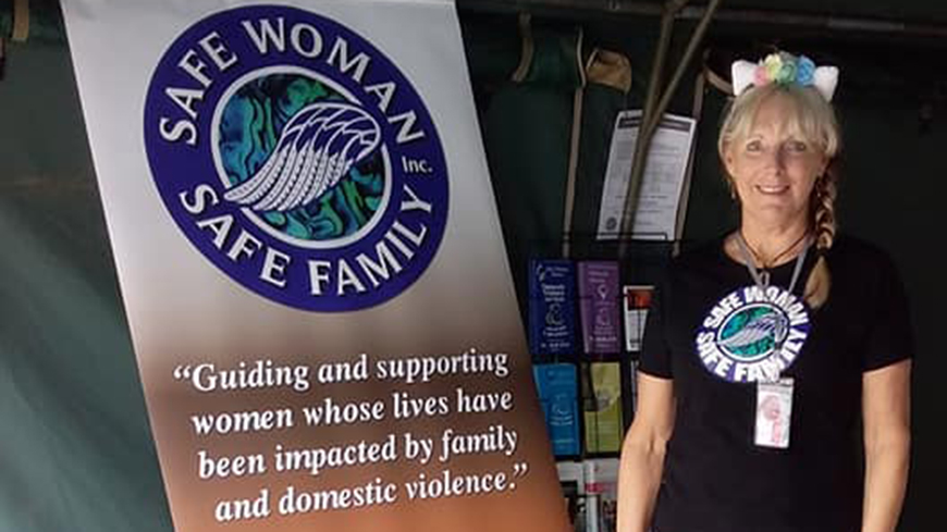 Woman standing alongside a promotional banner