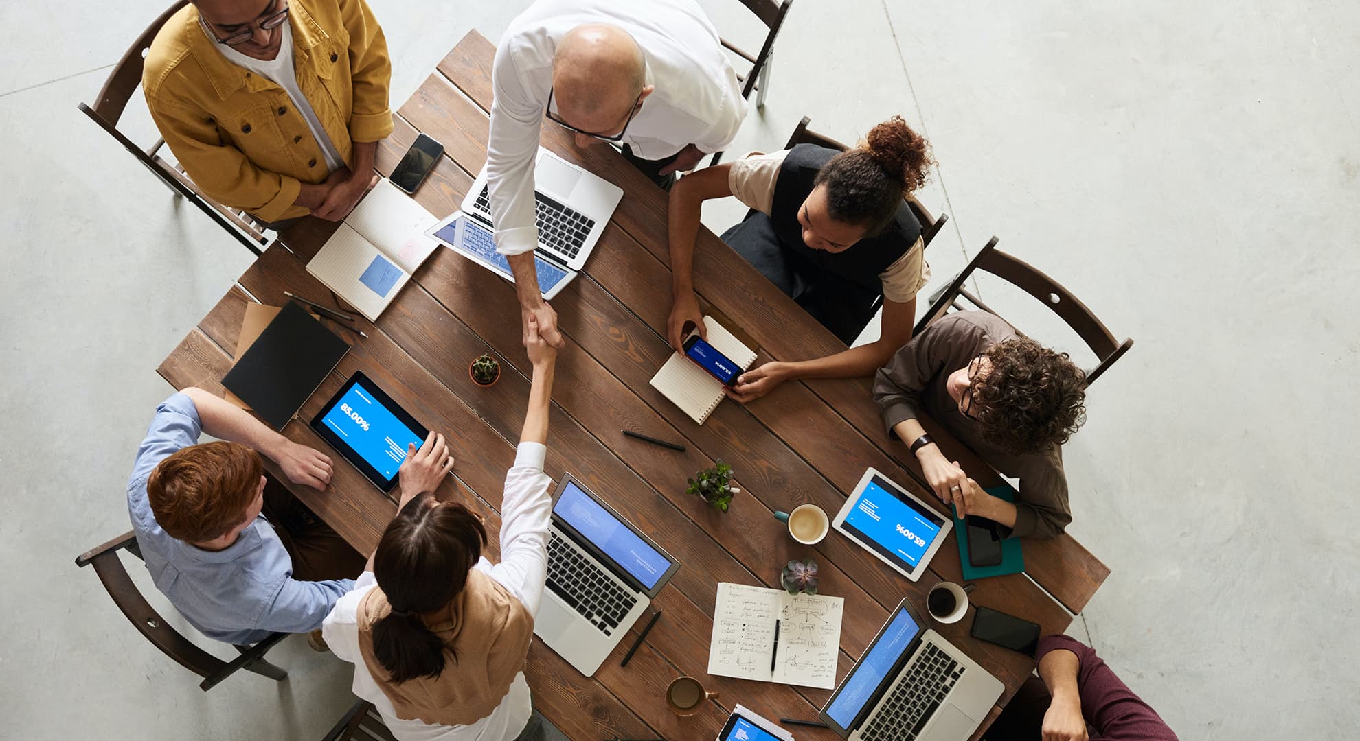 People sitting in a meeting around a wooden table.