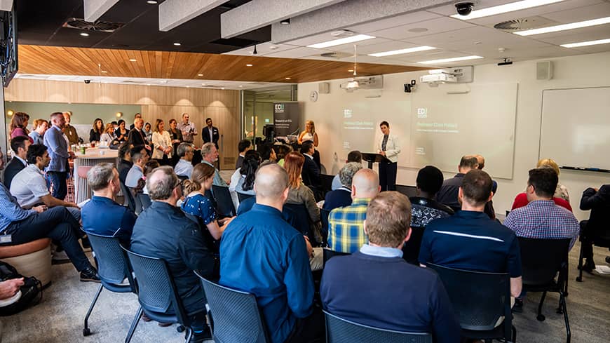 Woman at a podium in front of a seated crowd