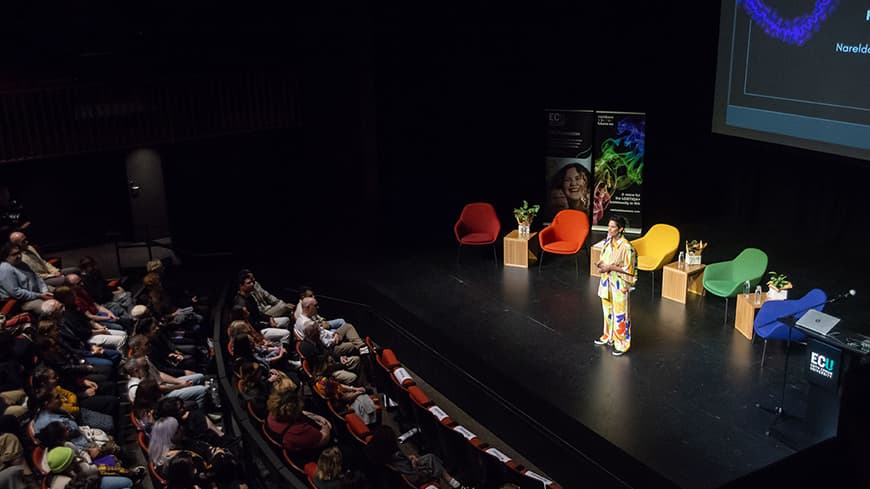 Narelda Jacobs speaking on stage at The Playhouse Theatre at ECU City.