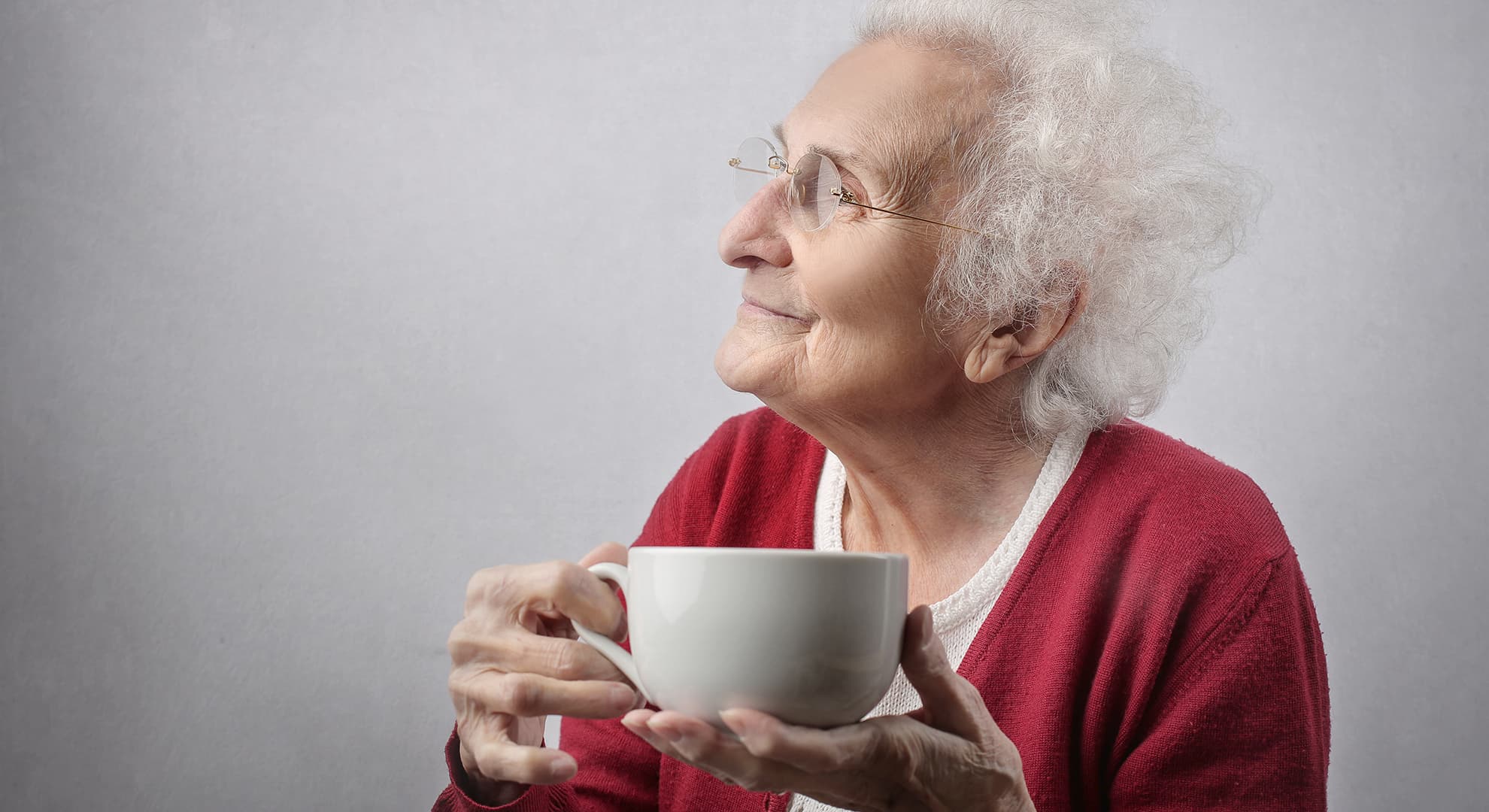 Elderly woman drinking a cup of tea.