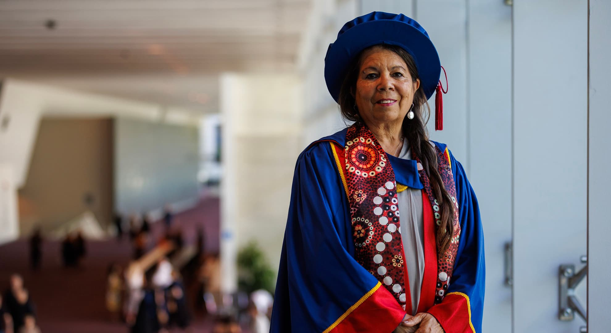 Lady standing in full doctoral regalia