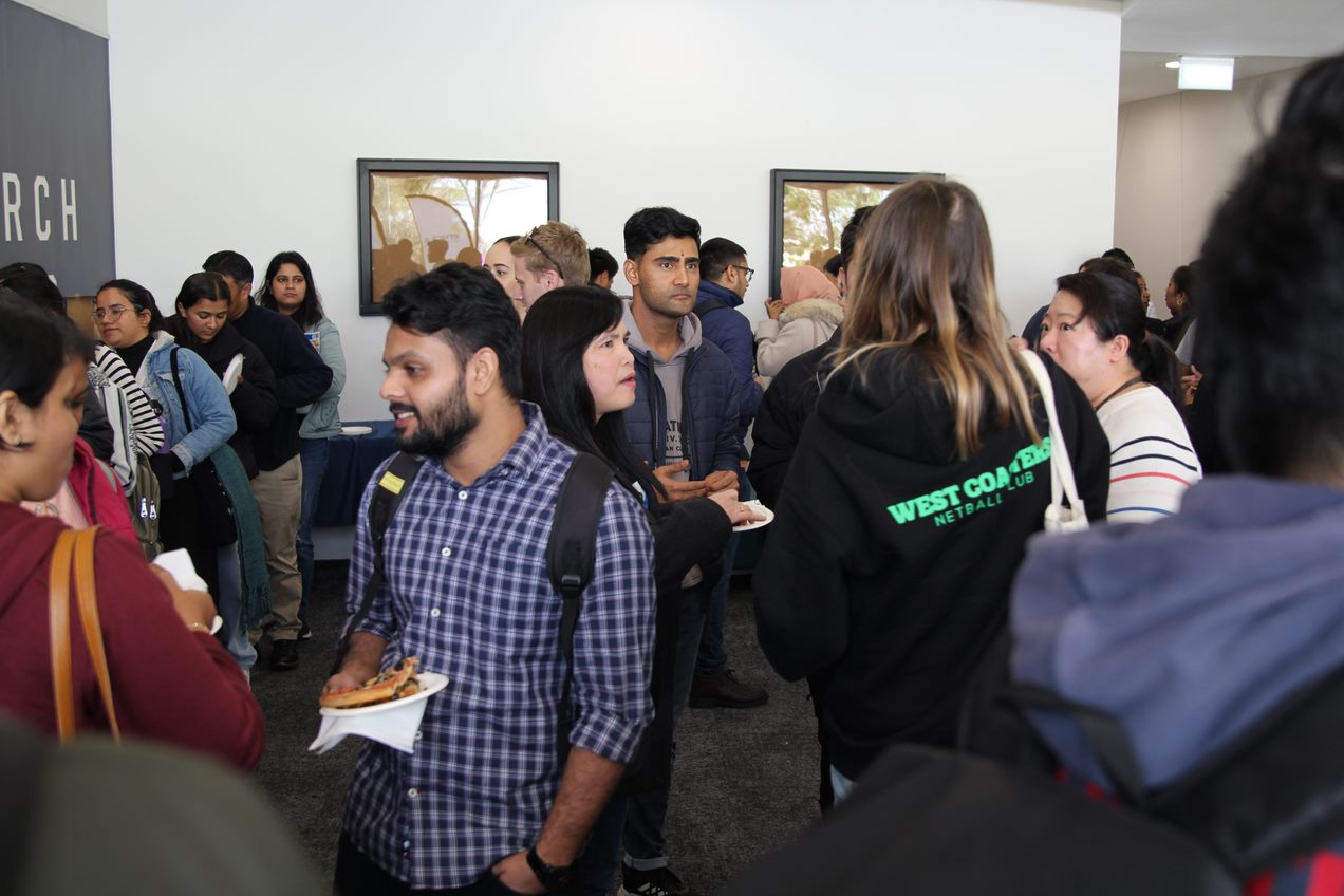 close up shot of postgrad students eating pizza with lecturers