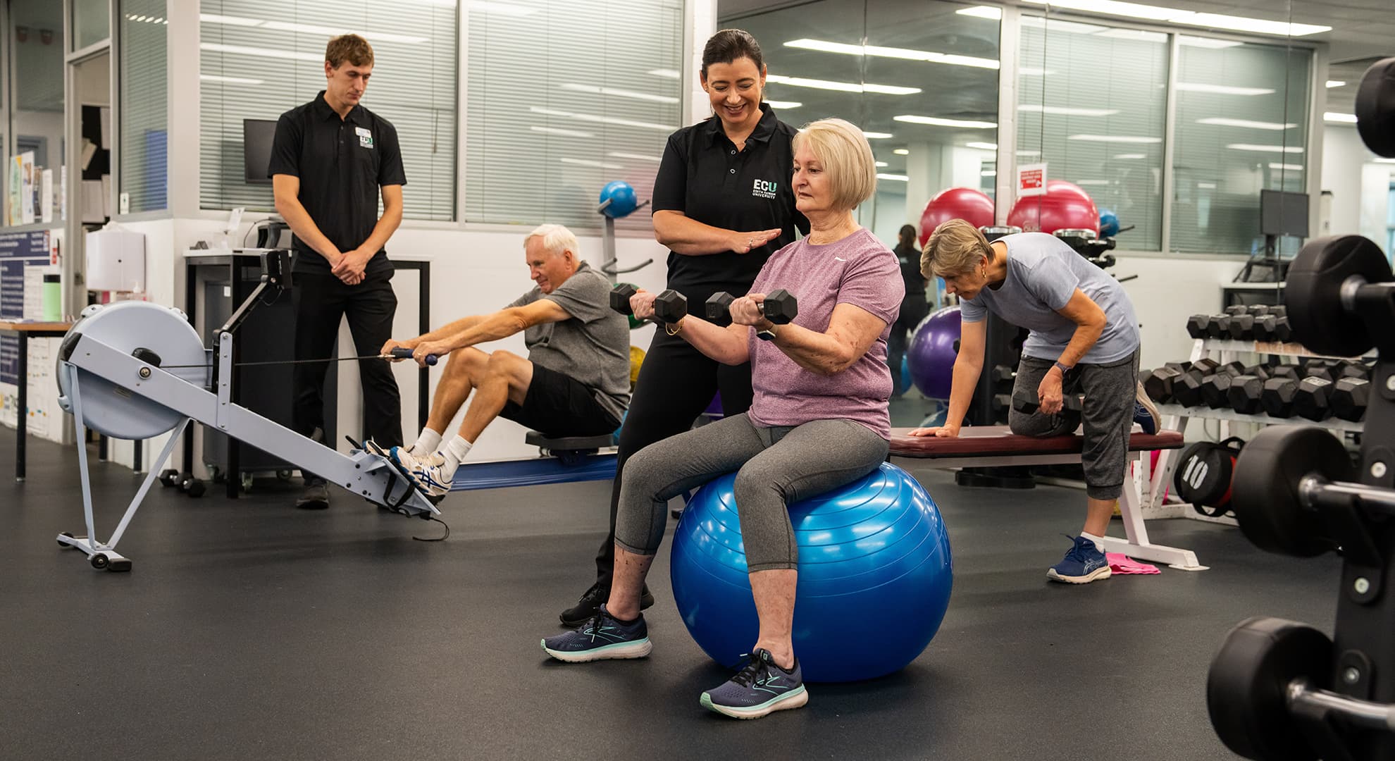 Gymnasium with older people working out with the support of health staff.