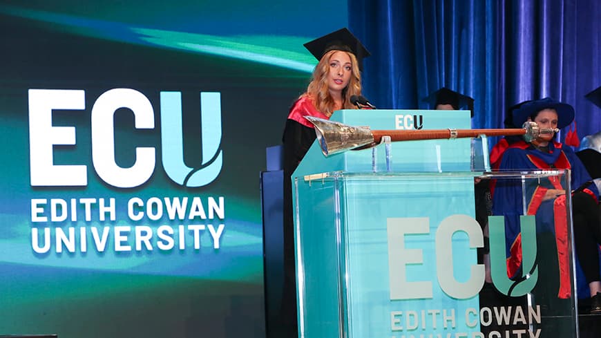 A woman giving a speech at a graduation ceremony
