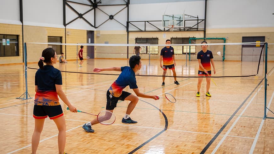 Four students playing badminton