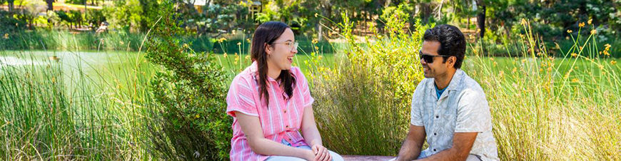 Two student sitting near a lake