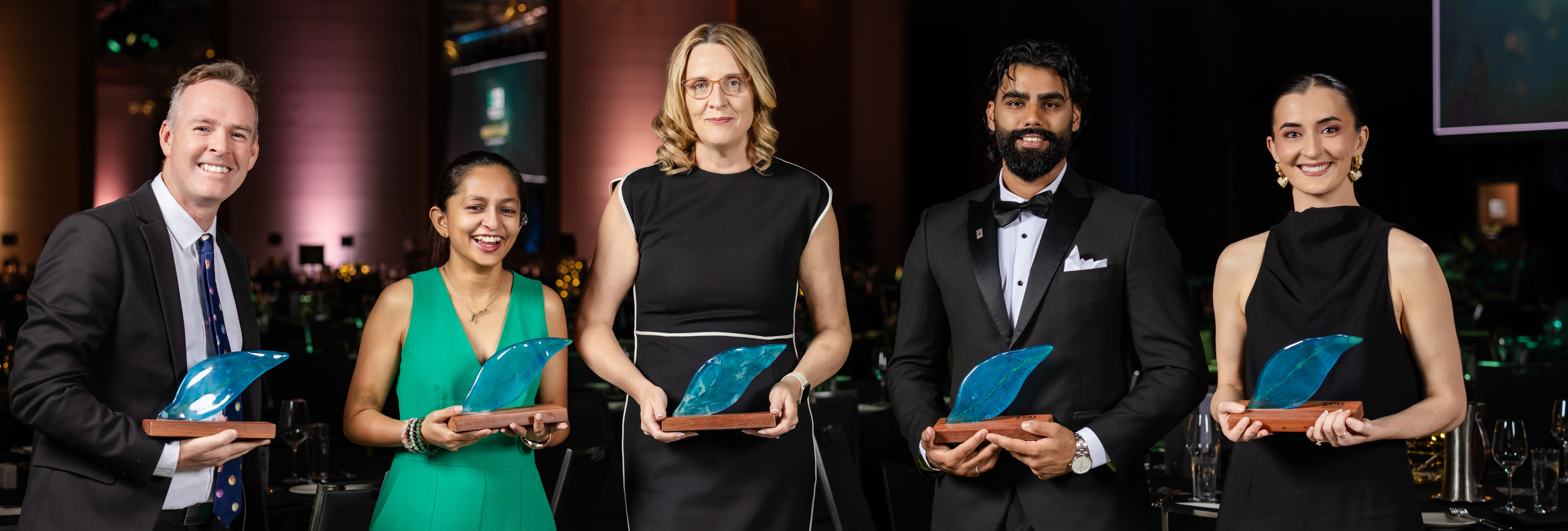 A group of award winners posing with their trophies