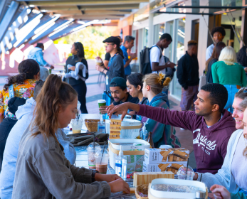 Students and staff gathered around tables, taking part in activities and chatting with one another.