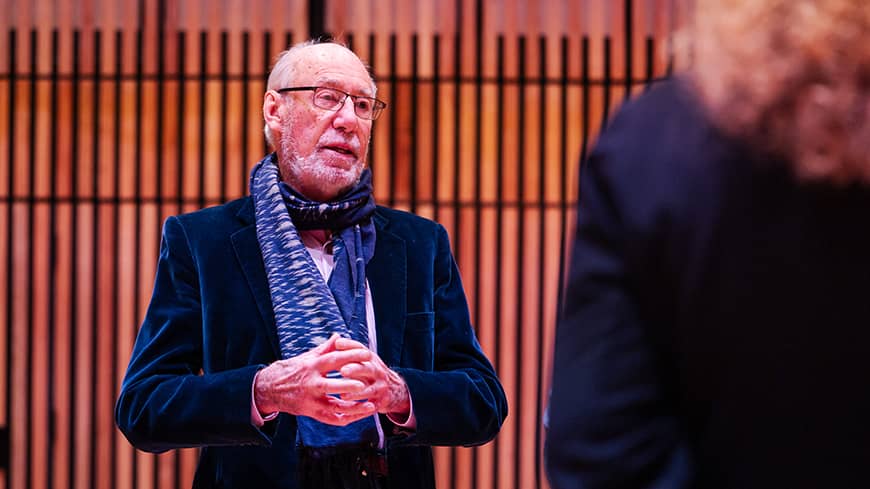An image of a man reflecting and talking in an auditorium