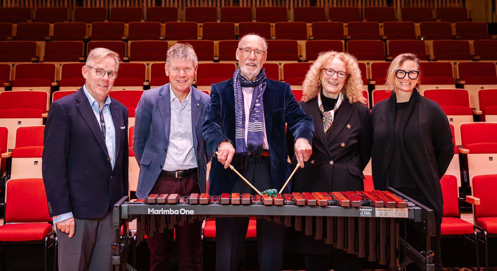 A group of people standing near a xylophone
