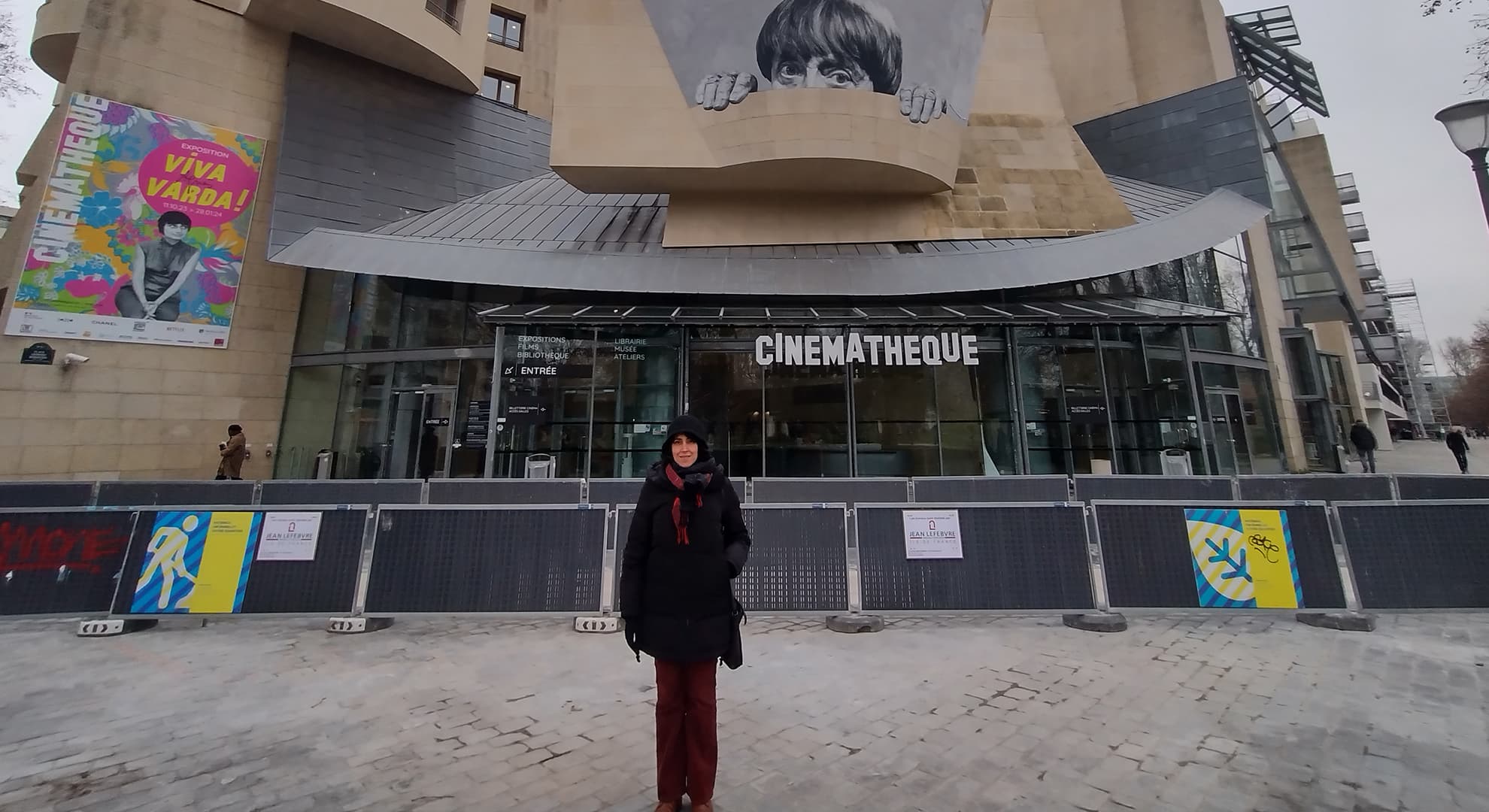 Shirin Barghnavard in front of a large cinema building with a sign saying Cinematheque