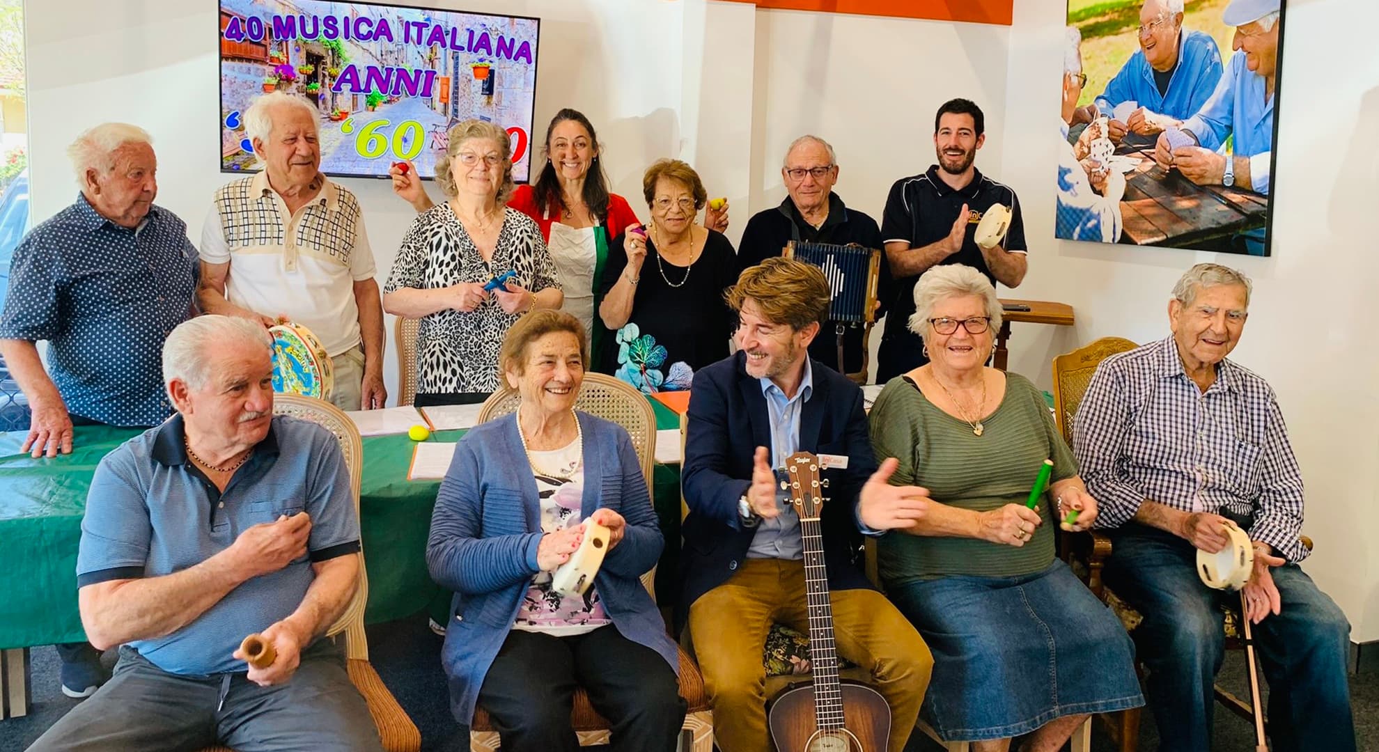 The choir with Dr Marino sitting in the middle, everyone smiling and laughing together.