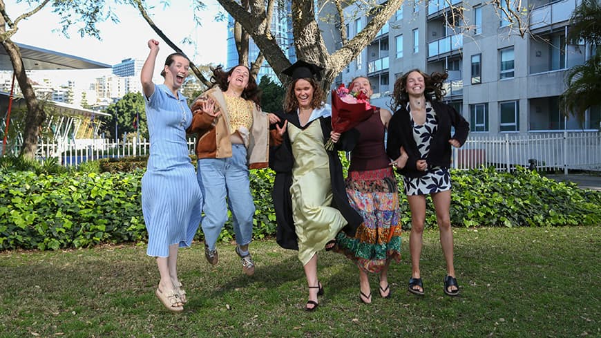 Graduate and friends joyfully jumping in the air