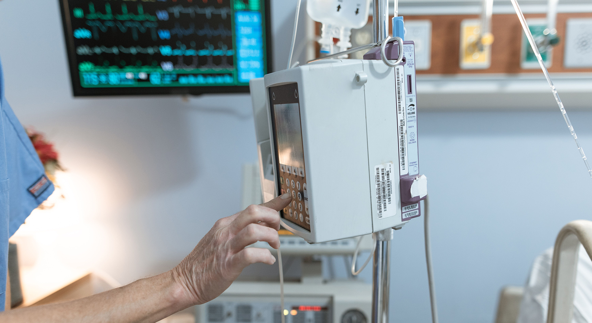 Nurse programming medical equipment in a hospital setting.