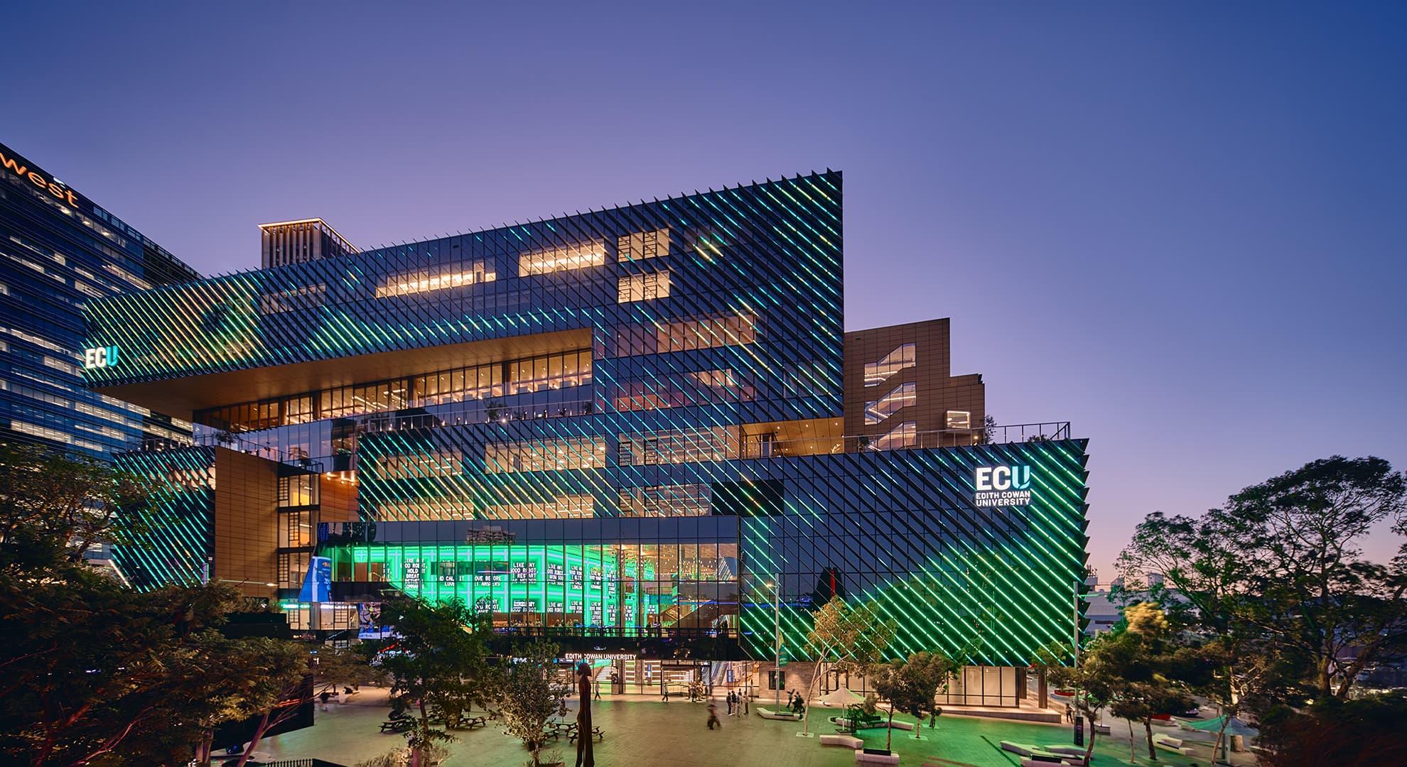 Night image of university building with bright coloured lights