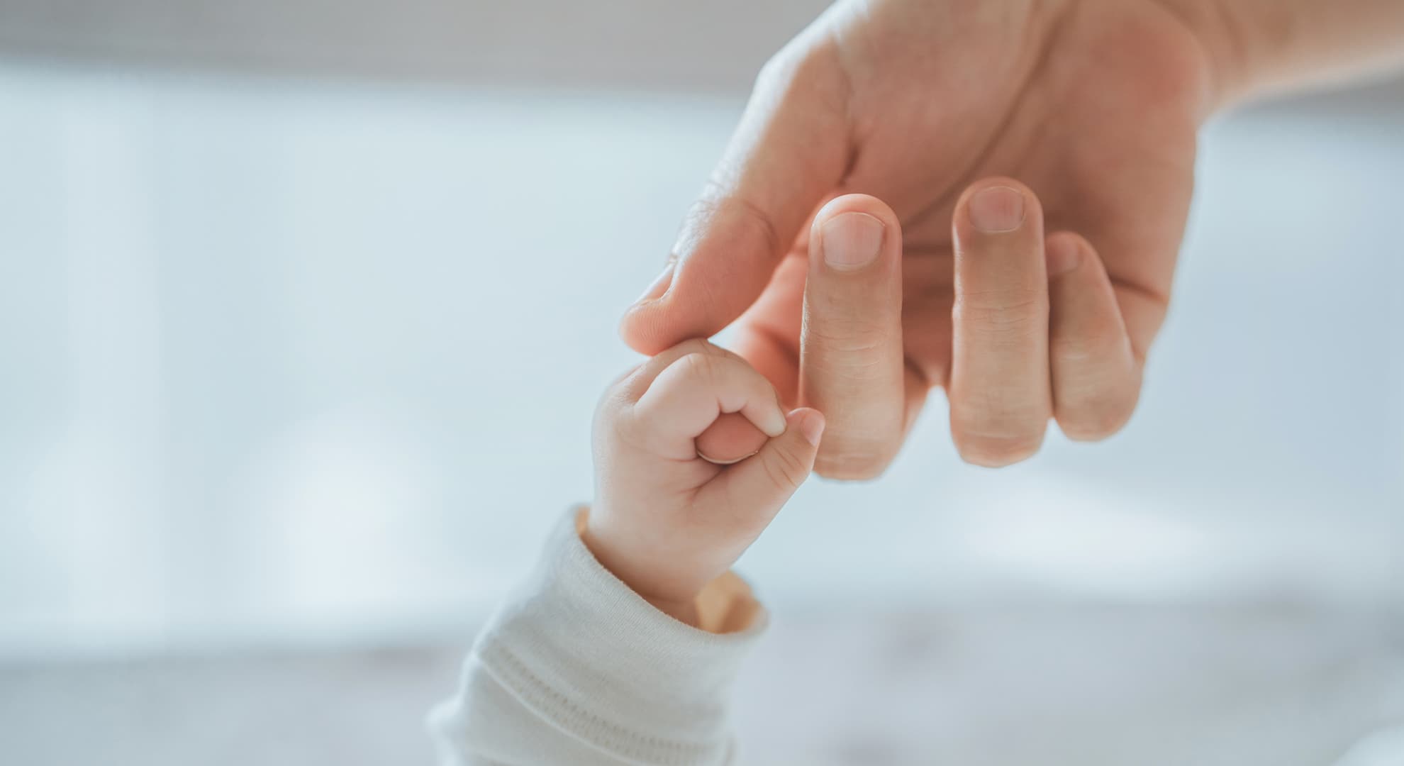 Mother's hand holding baby's hand