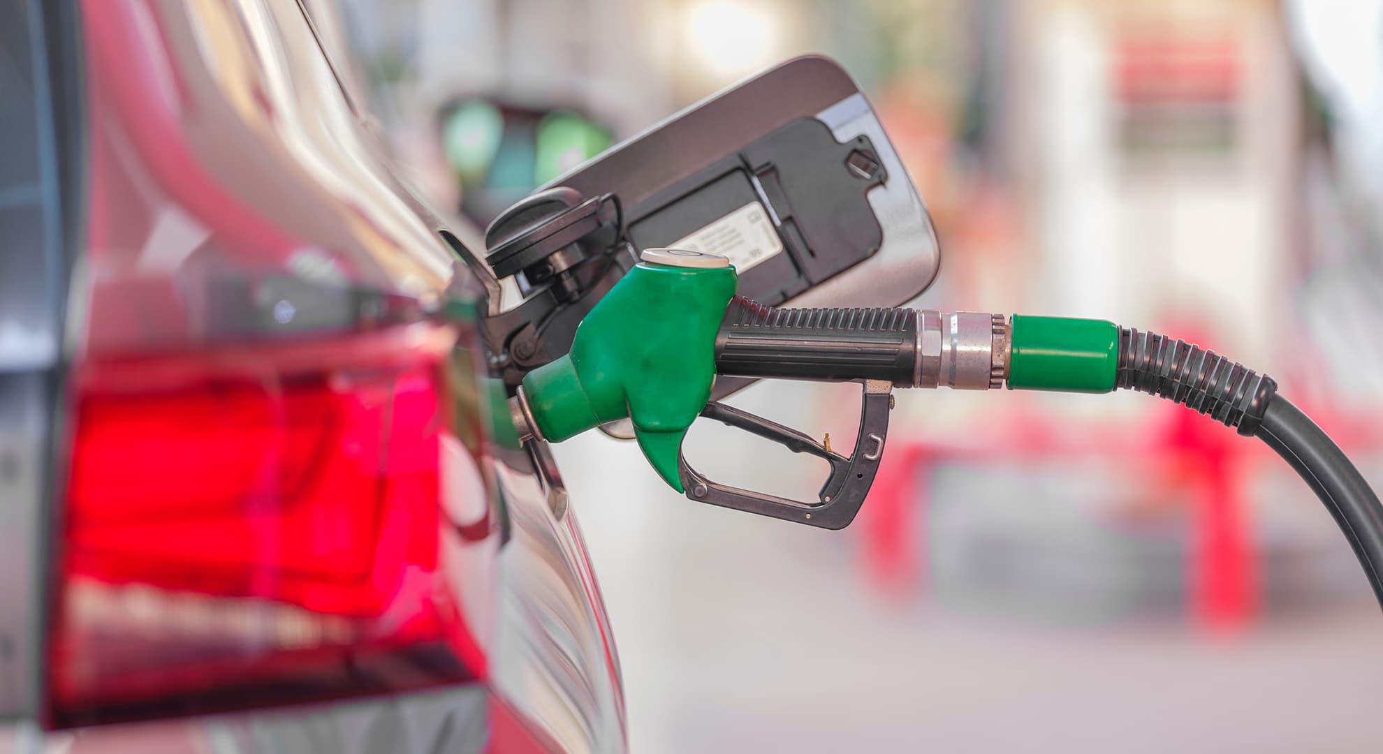 Green fuel pump refuelling a car.