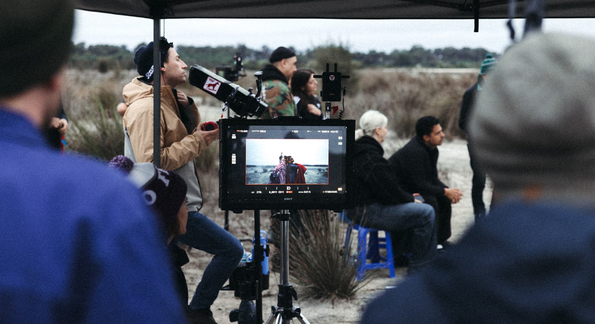 People standing near each other, looking at a small screen.