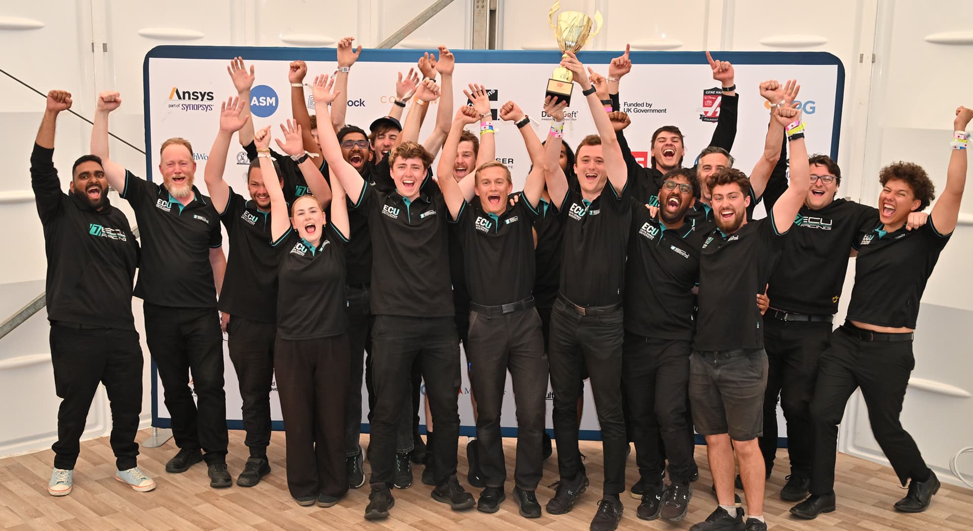 The team holding up their trophy