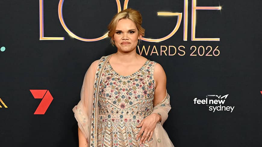 Woman standing in front of Logies banner.