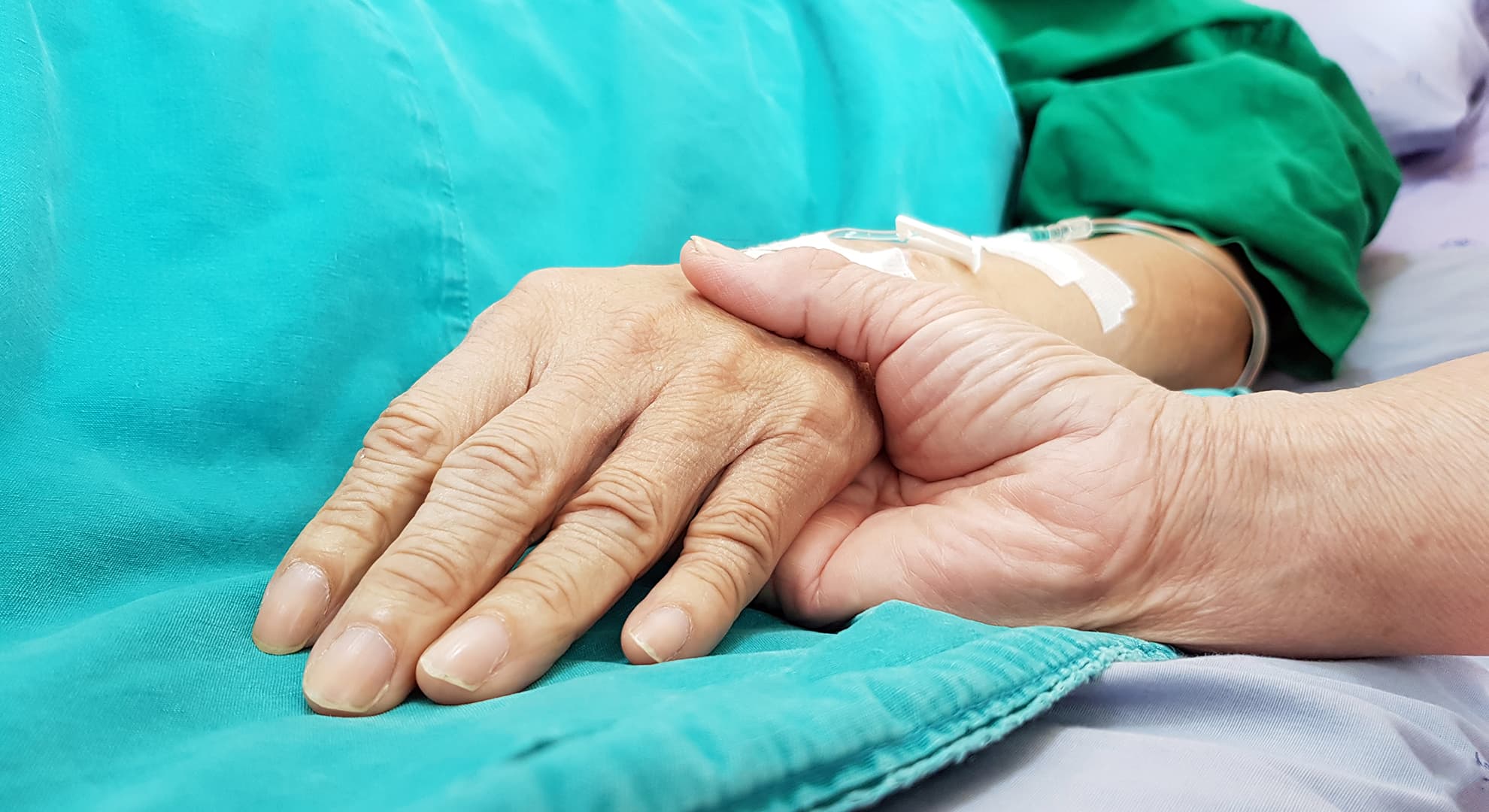 Person holding hands and providing end of life care.