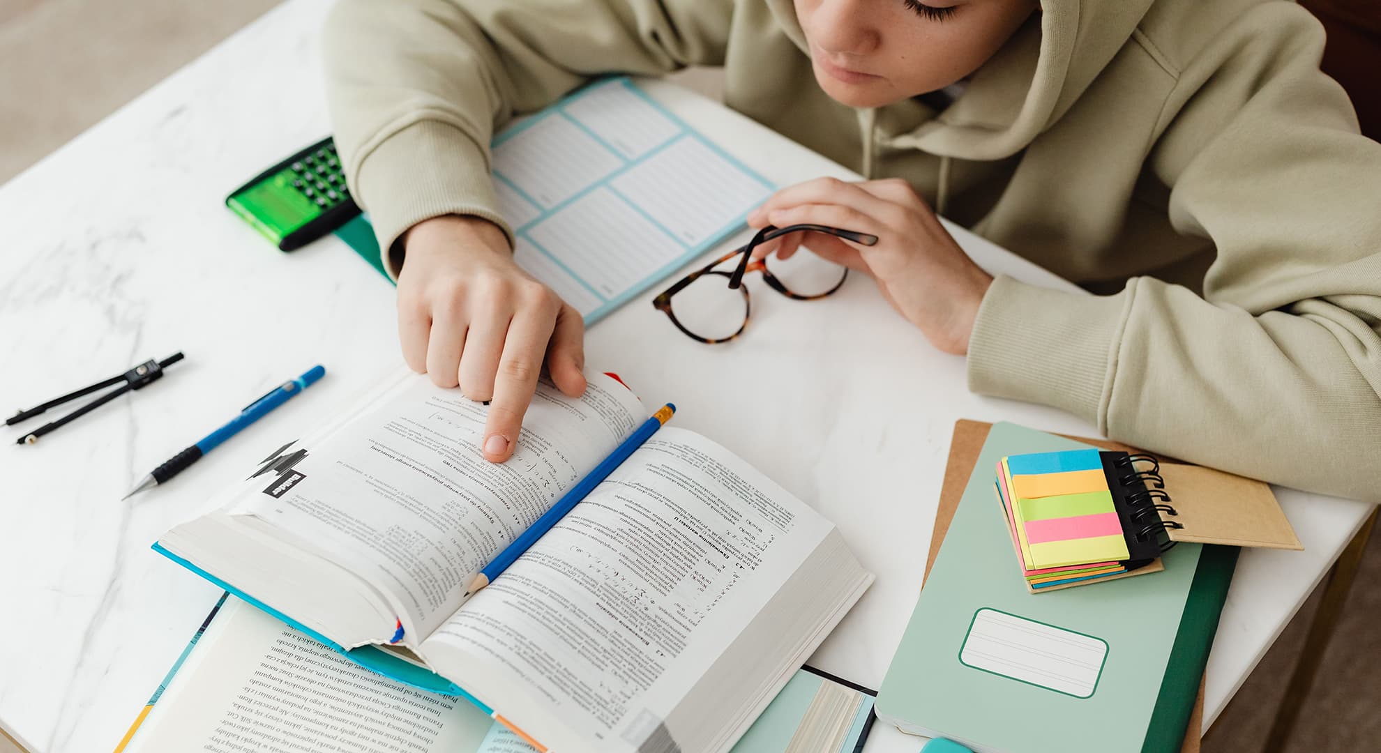 Child in hoodie studying.