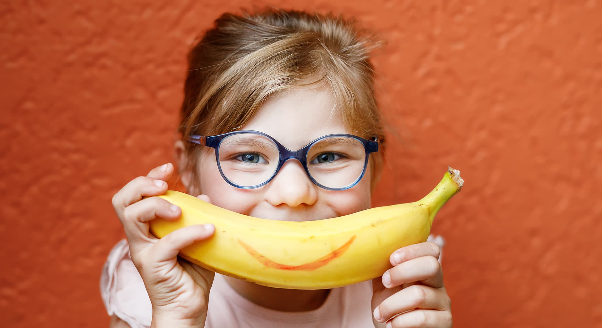 Little girl holding a banana