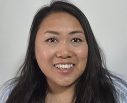 Headshot of a woman with long wavy dark hair