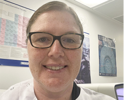 Headshot of a woman with glasses on in the lab 