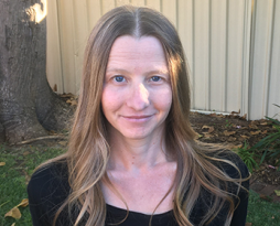 Image of a woman with long dark blonde hair in black top