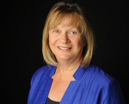 Headshot of a female professor with blonde hair and a blue blouse