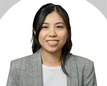 Photo of a young woman with dark hair wearing a light grey blazer