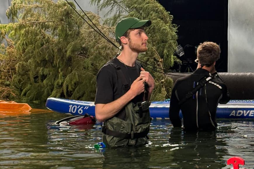 Two men stand waist deep in water